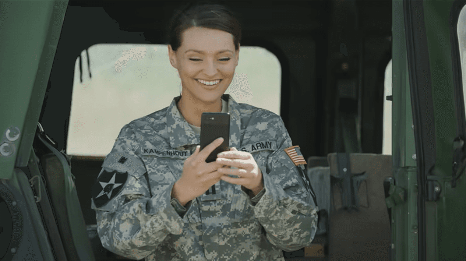 Service member smiling at phone